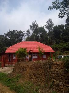 a red house with a red roof on a hill at Chilly Coorg in Virajpet