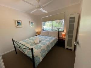 a bedroom with a bed and a window at At Melaleuca 3 in Point Lookout