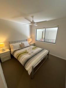 a bedroom with a large bed with a window at At Melaleuca 3 in Point Lookout