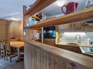 une cuisine avec des placards en bois et une table en bois dans l'établissement Appartement Val-d'Isère, 3 pièces, 7 personnes - FR-1-567-24, à Val dʼIsère