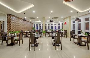 a restaurant with tables and chairs in a room at Golden Star Hotel & Apartment by THG in Da Nang