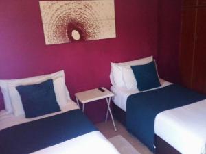 a hotel room with two beds and a table at Kubo Bed and Breakfast in Cofimvaba