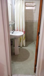 uma casa de banho com um lavatório branco e um chuveiro em Lo de Liliana em Tanti