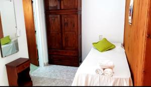 1 dormitorio con 1 cama con almohada verde y toallas en Lo de Liliana in 