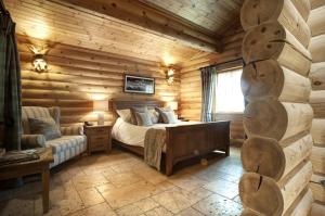 a bedroom with a bed in a log cabin at Crab Manor Hotel in Thirsk