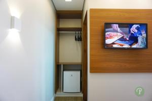 TV en la pared de una habitación en Hotel Park, en Valparaíso de Goiás