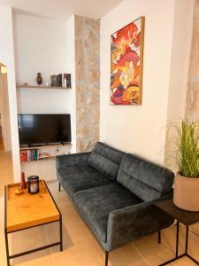 a black couch in a living room with a tv at Stella Apartments in Kaštela