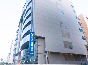 a tall white building with a blue sign on it at Golden Tulip Deira Hotel in Dubai