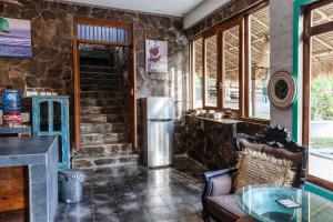 a kitchen with a refrigerator in a stone wall at Unique Balian beach house in Antasari