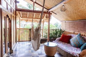 a porch with a hammock and a swing at Unique Balian beach house in Antasari