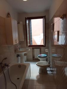 uma casa de banho com 2 lavatórios, um WC e uma janela em Two Steps from Rialto em Veneza