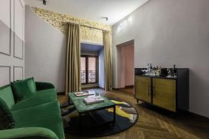 un soggiorno con divano verde e tavolo di Chapter Roma a Roma