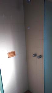 a bathroom with a shower with white tiles at Hotel Elo Curitiba in Curitiba