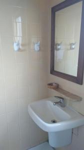 ein weißes Badezimmer mit einem Waschbecken und einem Spiegel in der Unterkunft Hotel Elo Curitiba in Curitiba