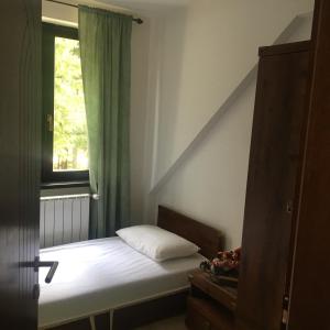 a small bedroom with a bed and a window at Villa Pahuljica in Jahorina