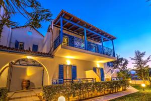 a white house with a balcony at night at Cozy Apartment Amoudara Heraklion Crera-4 in Ayía Marína