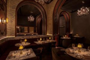 a restaurant with tables and chairs and a mirror at Chapter Roma in Rome
