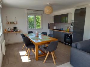 cocina con mesa de madera y sillas en Appt spacieux et lumineux pour 6 pers, en Giffaumont-Champaubert
