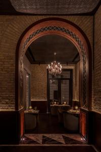 une salle à manger avec un lustre et un mur en briques dans l'établissement Chapter Roma, à Rome