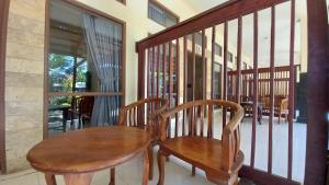 drewniany stół i 2 krzesła na balkonie w obiekcie Wisma Bunda w Gili Trawangan