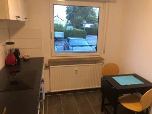 uma cozinha com uma mesa e uma janela com um carro no exterior em Relax am Bodensee em Friedrichshafen