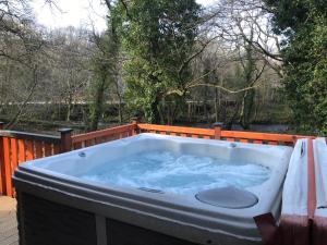 a jacuzzi tub on a wooden deck at L11 - The Harlech Lodge with Hot Tub in Bethesda