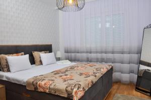 Un dormitorio con una cama grande y una lámpara de araña. en Guest House Atena en Nova Pazova