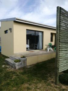 una pequeña casa con terraza y mesa de picnic en Nirvana, en Struisbaai