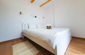 um quarto com uma cama branca e uma caixa. em Domeniul Acasa in Vadu Izei Maramu em Vadu Izei