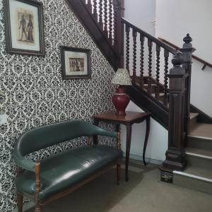 un escalier avec une chaise verte et un escalier dans l'établissement Hotel Dona Lú, à São Paulo