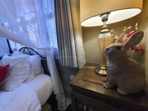 a stuffed rabbit sitting on a table next to a lamp at The Unforgotten B&B in Bangkok