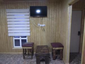 a room with two stools and a tv on the wall at Cabañas 644 in Porvenir