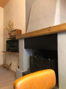 a yellow chair in a room with a fireplace at Corte Bargagli, dolce casa in palazzo toscano in Sarteano