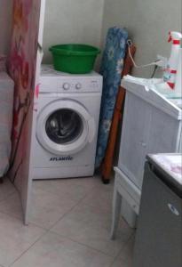a washing machine with a green bowl on top of it at Athena appartamenti Castro in Castro di Lecce