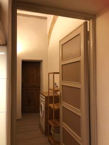una porta che conduce a una cucina con lavatrice e asciugatrice di Corte Bargagli, dolce casa in palazzo toscano a Sarteano