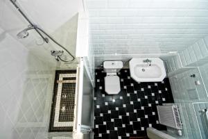 a bathroom with a toilet, sink, and bathtub at British Club Lviv in Lviv