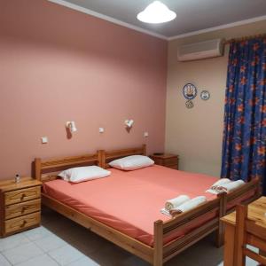 a bedroom with a large bed with red sheets at ChiosRoomsMaria in Kalamoti