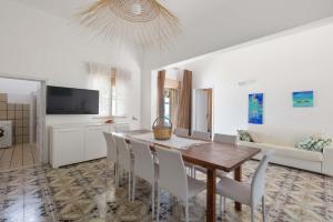 a kitchen and dining room with a table and chairs at Villa Pace by BarbarHouse in Torre Lapillo