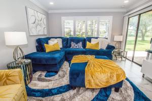 a living room with a blue couch and yellow pillows at Lavish Living ~ Ground Floor Corner Unit in Wesley Chapel