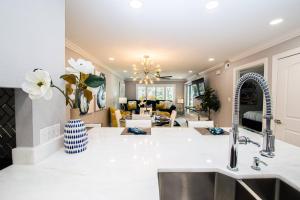 a kitchen with a sink and a living room at Newly Listed! 20 Percent Off! Golf and Tennis Community - Lavish Living in Wesley Chapel