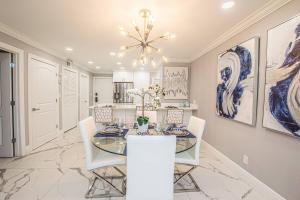 a dining room with a glass table and white chairs at Newly Listed! 20 Percent Off! Golf and Tennis Community - Lavish Living in Wesley Chapel