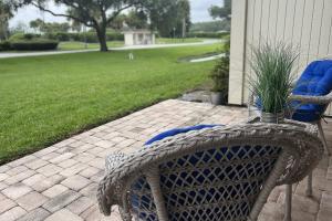 a patio with a chair and a table and a lawn at Lavish Living ~ Ground Floor Corner Unit in Wesley Chapel +42 photos