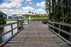 a wooden bridge over a body of water with a fountain at Lavish Living ~ Ground Floor Corner Unit in Wesley Chapel