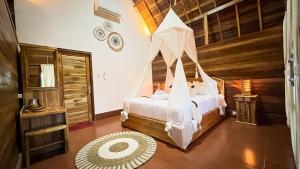a bedroom with a bed with a mosquito net at Griyatama Bungalow in Nusa Penida