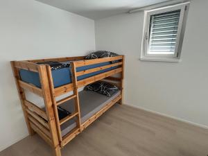 a bedroom with bunk beds in a room with a window at Great new apartment surrounded by nature. in Schattdorf