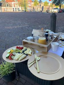 una mesa con dos platos de comida y una bandeja de zumo en By Goselink, en Alkmaar