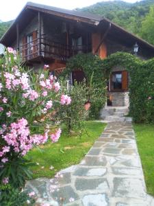 a house with a pathway leading to it with flowers at Chalet di Montagna in San Giuliano