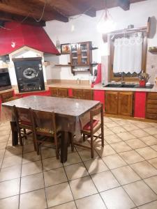 a kitchen with a large wooden table and chairs at Chalet di Montagna in San Giuliano