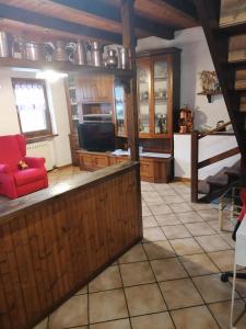 a large kitchen with a red couch in a room at Chalet di Montagna in San Giuliano