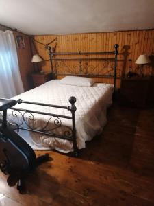 um quarto com uma cama e uma mala no chão em Chalet di Montagna em San Giuliano